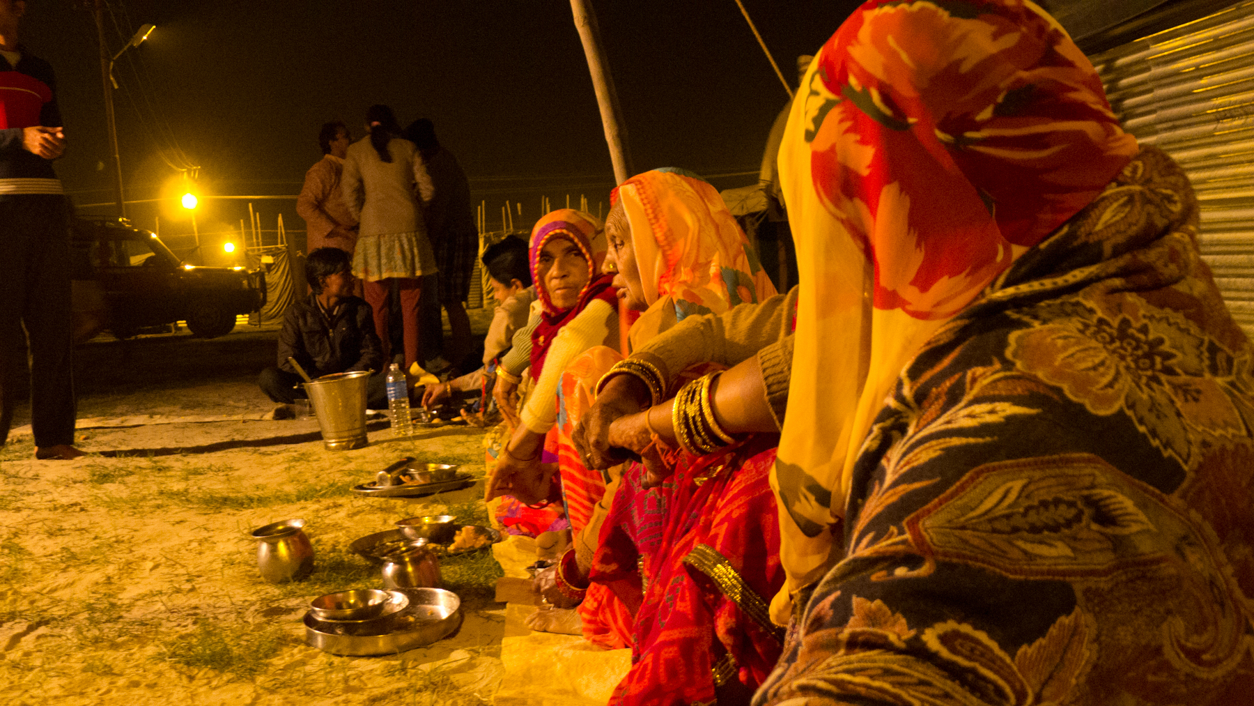 Le repas du soir, en commun, avec nos hôtes de Bundi. On mange par terre tandis que d'autres font le service.